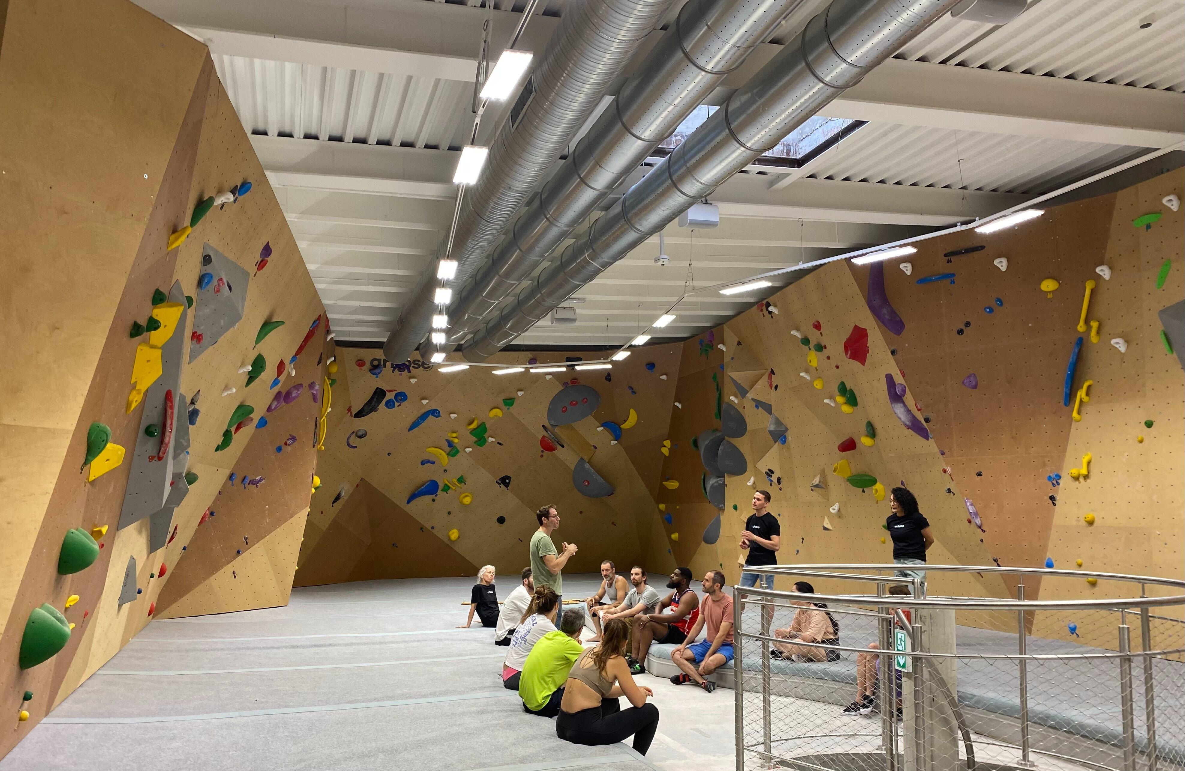 Débutant en escalade sur un mur de bloc dans une salle Arkose